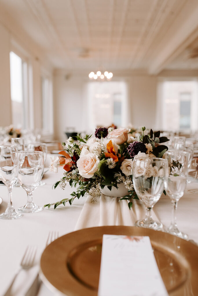 A table with flowers in a centerpiece set for a wedding dinner celebration