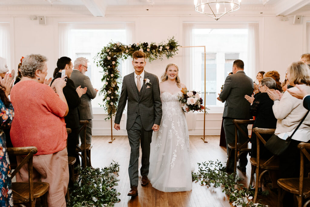 A bride and groom exiting the aisle after saying their vows, just married